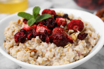 Oatmeal with freeze dried strawberries and mint on table, closeup