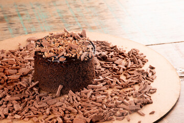 chocolate cake with chocolate shavings and chocolate cream on a rustic bistro table CLOSE-UP in the corner