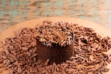 chocolate cake with chocolate shavings and chocolate cream on a rustic bistro table CLOSE-UP