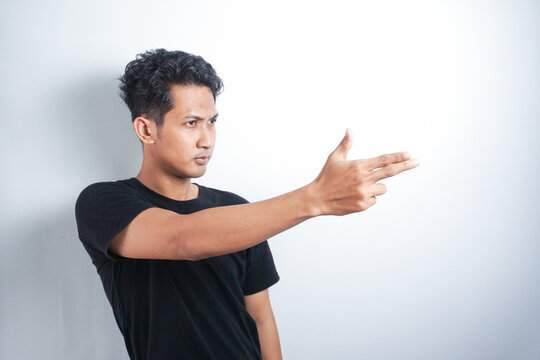 Strange asian man makes a gesture with hands like it a gun. White background.