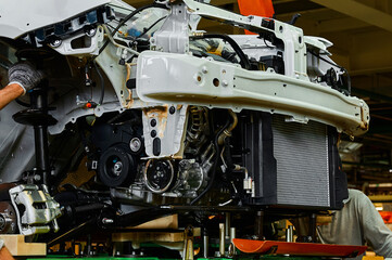 Installing of motor into automobile room in workshop