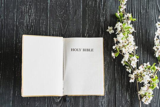 The Bible with spring flowers on a wooden background. Concept for faith, spirituality and religion. Peace, hope, dreams concept