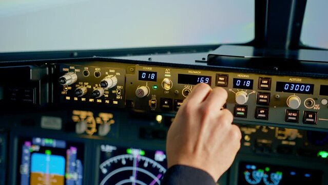 The pilot presses the power buttons on the control panel to control the aircraft in front of the cockpit windshield