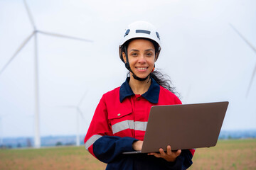 windmill engineer woman use laptop computer inspection and progress check wind turbine farm.