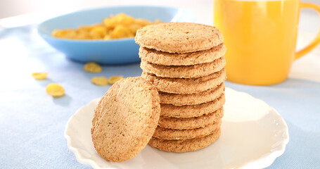 Fototapeta na wymiar oatmeal cookies close-up. whole grain product. healthy breakfast on a sunny morning. pastries on a blue table. sweets on a plate with corn flakes.