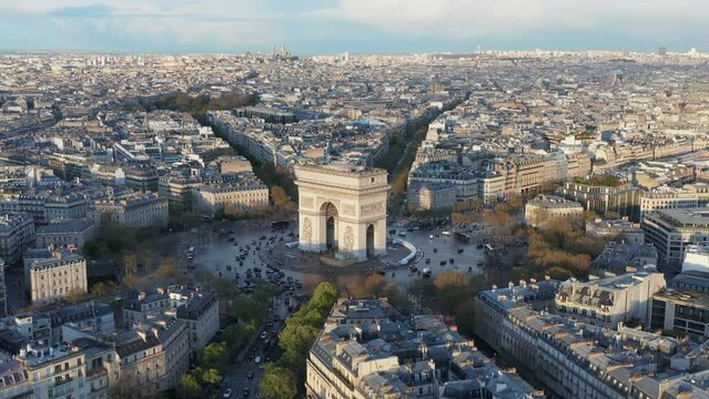 Flying slowly around Arc de Triumph, Paris city panorama, streets wet after rain