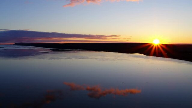 Aerial Shot Of Clouds Reflection On Sea Against Sky At Sunset, Drone Descending Near Silhouette Land - Bering Sea, Alaska