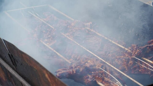 A roaster in China roasts a whole crispy-skinned pork over charcoal fire