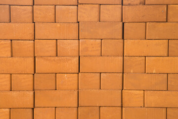 Obraz premium Reddish-brown bricks stacked together, textured background.