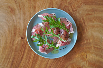 Melon Prosciutto with wild rocket. Italian appetizer. Top view with selective focus