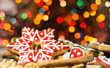 gingerbread cookies and spices over christmas light background close up