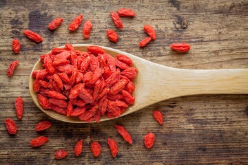 goji berries in a wooden spoon on a rustic background