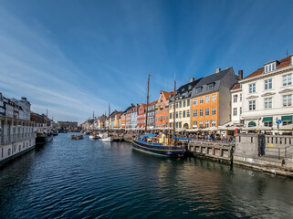 Fototapeta na wymiar view of Nyhavn a 17th-century waterfront, canal and entertainment district in Copenhagen, Denmark. Lined by bright colored 17th and early 18th century townhouses