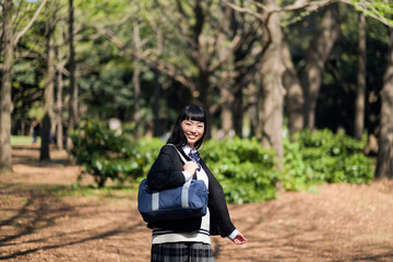 新緑の公園を散歩する女子高生