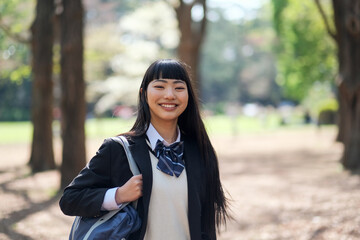 新緑の公園で微笑む女子高生