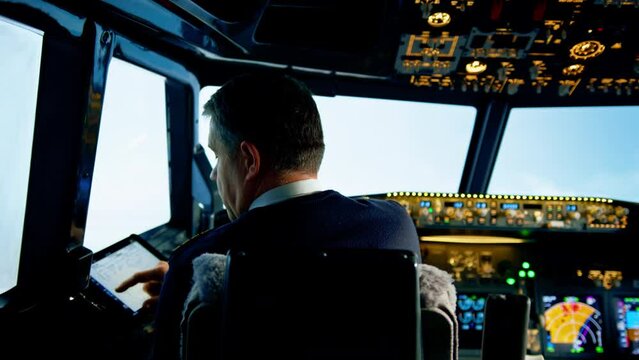 the pilot holds a tablet in his hands, looks at the flight route and chooses the landing place of the plane
