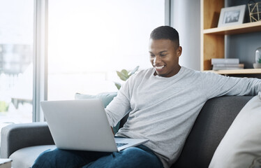Black man with laptop, streaming online and relax in living room, subscription service with internet and happiness. Technology, connectivity and male person chill at home watching movie on sofa