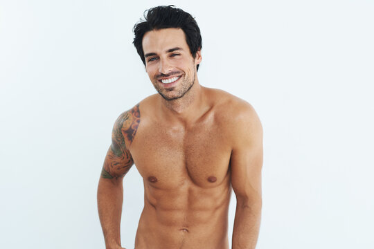 Portrait, fitness and man with body, muscle and abdomen against a white studio background. Male person, happy model and guy with abs, mockup and shirtless with workout goal, happiness and wellness