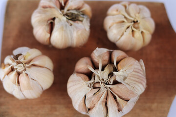 Fresh garlic on a cutting board on a white background