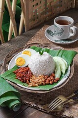 Asian cuisine Nasi Lemak is a rice dish infused with coconut milk. Served with sambal sauce, fried anchovies, fried peanuts, boiled eggs, and fresh cucumber.