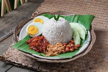 Asian cuisine Nasi Lemak is a rice dish infused with coconut milk. Served with sambal sauce, fried anchovies, fried peanuts, boiled eggs, and fresh cucumber.