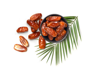 Top view of Dried dates fruits in black bowl with leaf isolated on white background.