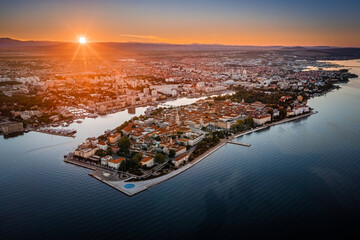 Zadar, Croatia - Aerial panoramic view of the old town of Zadar by the Adriatic sea with Zadar skyline, sea organ, blue sky and golden rising sun on a bright summer morning
