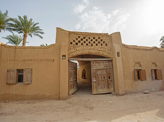 Old wooden entrance gate doorway in egyptian mud brick house
