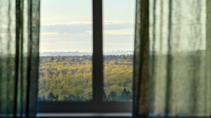 Window with curtains, window sill and clouds floating behind the glass