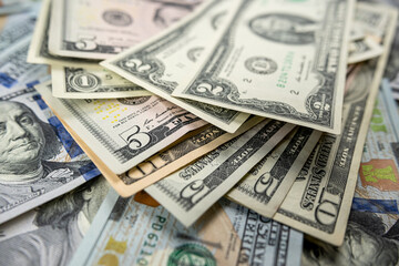 1 2 5 10 100 Different dollar bills in a pile as background