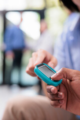 Close up of physician doing asian patient hypertension examination using tonometer in hospital reception, measuring blood and pulse pressure. Medic checking hypotension with cardiology instrument