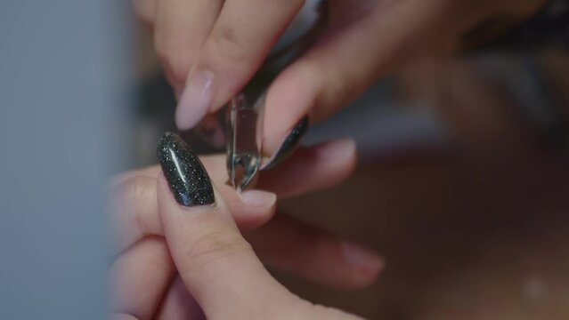 Manicurist Cutting The Hangnail Of Customer Using Cuticle Nipper. - closeup