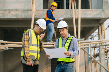 Architect caucasian man working with colleagues mixed race in the construction site. Architecture engineering on big project. Building in construction interior.