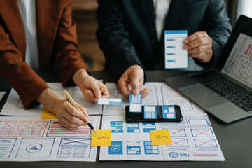  UX developer and ui designer brainstorming about mobile app interface wireframe design with...