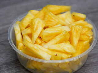 sliced fresh pineapple in a transparent container. healthy food and diet concept