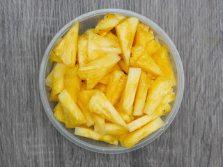 top view of sliced fresh pineapple in a transparent container. healthy food and diet concept