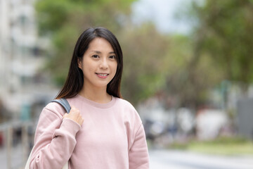 Woman smile to camera and stand on the street