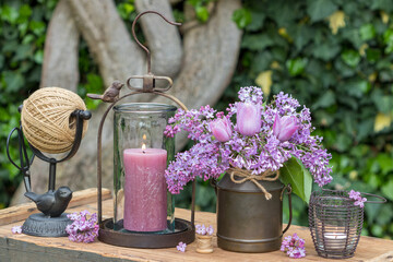 vintage Arrangement mit Blumenstrauß mit pink Tulpen und Flieder und Laterne