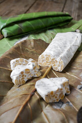 Raw tempeh or tempe. Tempe is fermented from soybeans wrapped with simpo leaf or jati leaf.