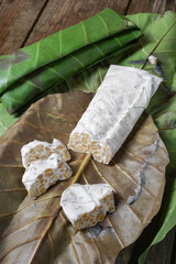 Raw tempeh or tempe. Tempe is fermented from soybeans wrapped with simpo leaf or jati leaf.