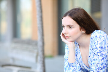 Pensive woman contemplating sitting in the street