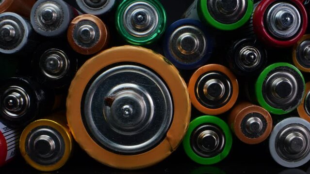Close-up shot of old alkaline batteries, commonly known as "AA" or "AAA". Captured in macro against a dark background.