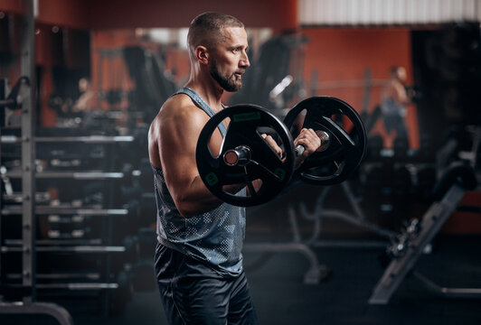 Bearded strong athletic fitness men pumping up arm muscles workout barbell curl fitness concept background - muscular bodybuilder men doing bodybuilding biceps exercises in gym