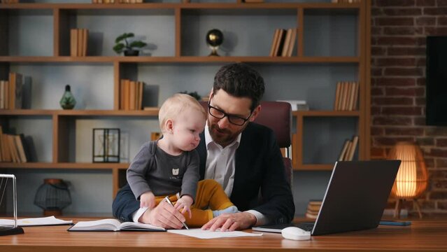 Writing document. Businessman in formal clothes is working indoors. With toddler.