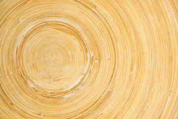 Top view of empty wooden bamboo plate closeup texture of circular pattern with copy space in horizontal format.