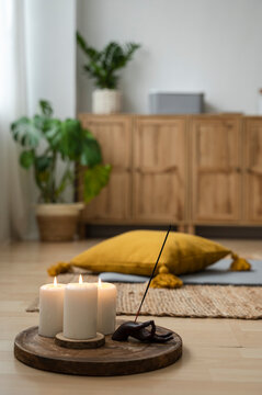 Candles and incense on wooden board at home