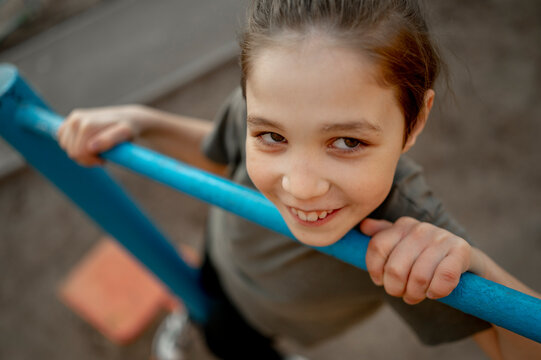Smiling boy climbing monkey bar at park