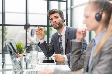 Happy young male customer support executive working in office