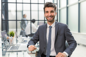 Portrait of handsome businessman sitting in office.
