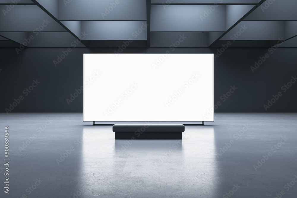 Poster front view on a bench on concrete floor in front of blank white illuminated screen with place for yo
